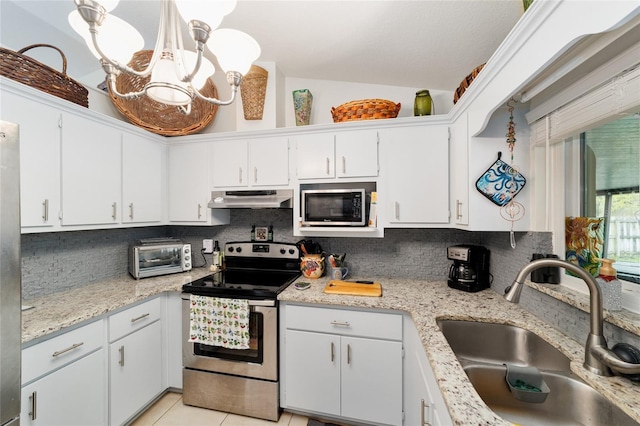 kitchen with stainless steel appliances, a sink, under cabinet range hood, and decorative backsplash