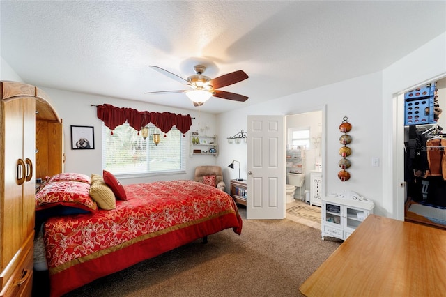 bedroom with a textured ceiling, ceiling fan, ensuite bath, and carpet flooring