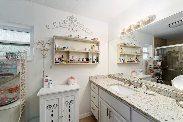 full bath with visible vents, a shower stall, and vanity