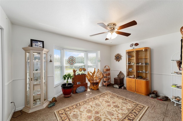 interior space with a textured ceiling, a ceiling fan, and baseboards