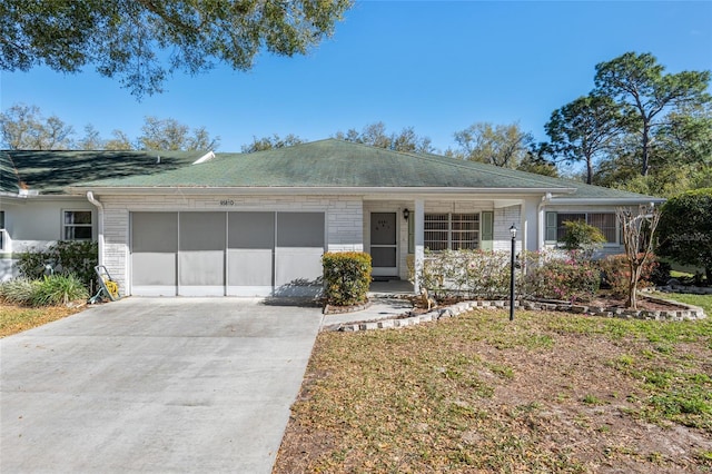 ranch-style house featuring a garage, concrete driveway, and brick siding