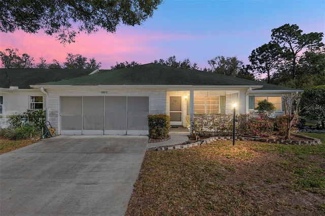 ranch-style house featuring driveway, brick siding, and an attached garage