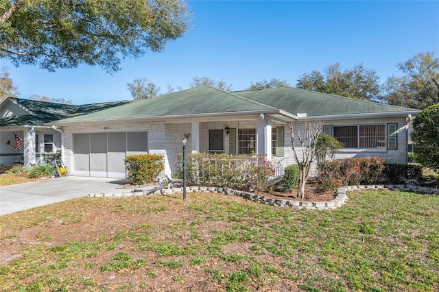 ranch-style home featuring an attached garage, brick siding, concrete driveway, and a front yard