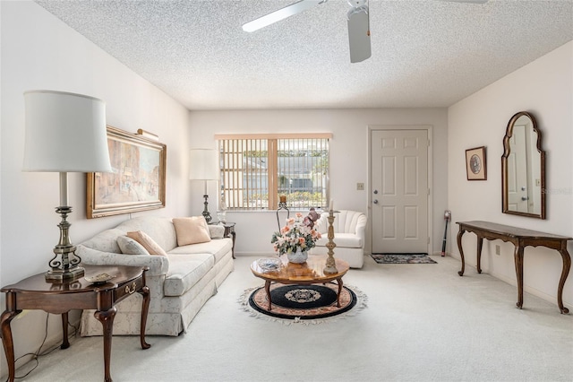 living room with a textured ceiling, a ceiling fan, and carpet flooring