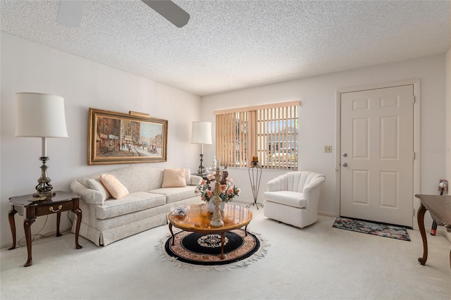 living area with carpet floors, a textured ceiling, and a ceiling fan