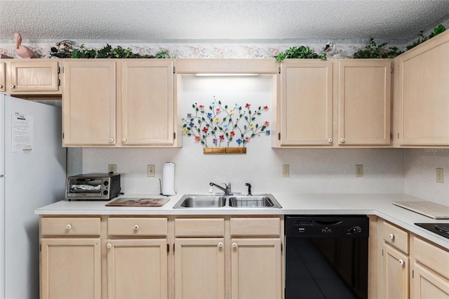 kitchen featuring black dishwasher, light brown cabinetry, a sink, and freestanding refrigerator