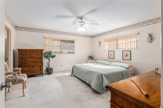 carpeted bedroom with a ceiling fan and a textured ceiling