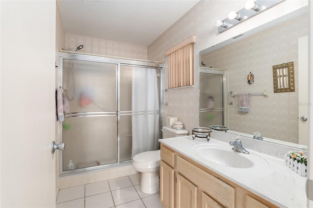 bathroom with a textured ceiling, toilet, and wallpapered walls