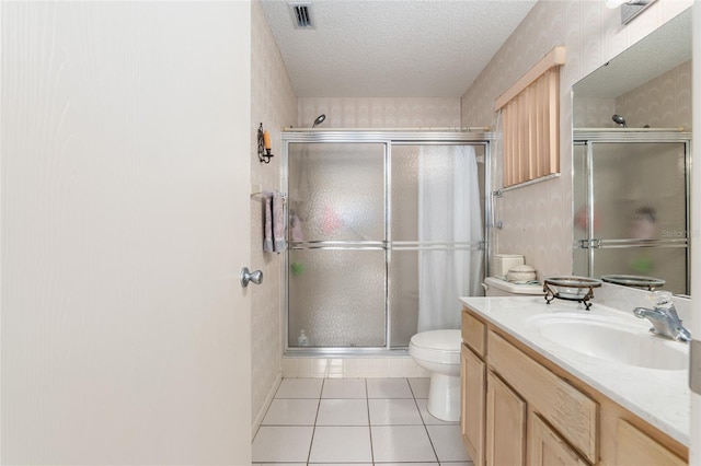 bathroom with a stall shower, visible vents, toilet, tile patterned flooring, and a textured ceiling