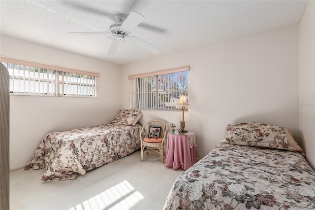 carpeted bedroom with a textured ceiling and a ceiling fan