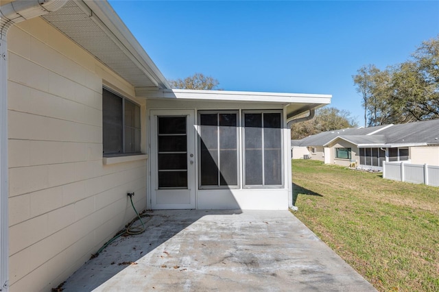 property entrance featuring a lawn and a patio area