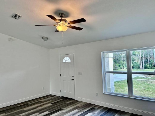 foyer entrance with visible vents, a ceiling fan, dark wood-type flooring, and baseboards