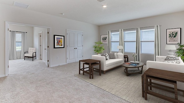 living room with light colored carpet, a textured ceiling, and baseboards