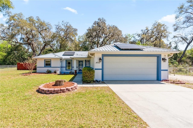 single story home with metal roof, an attached garage, and fence