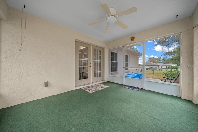 unfurnished sunroom featuring a ceiling fan and french doors