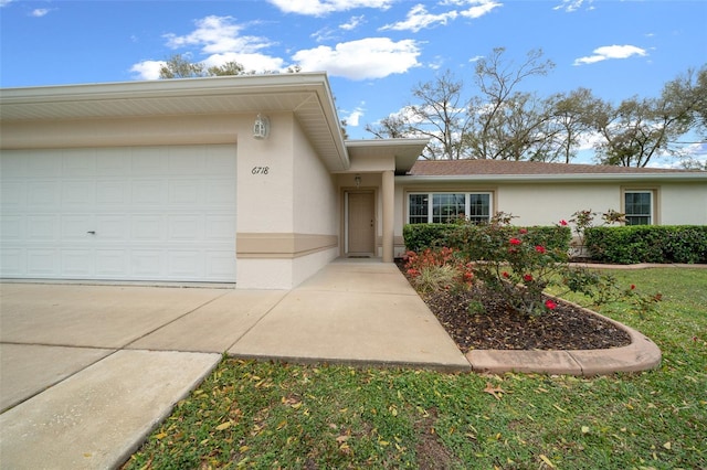 view of front of home with a garage, concrete driveway, and stucco siding