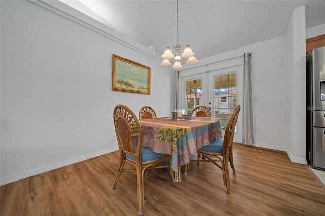 dining area featuring light wood-style flooring, baseboards, a chandelier, and french doors