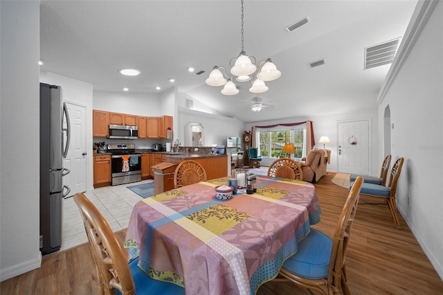 dining room with arched walkways, visible vents, and vaulted ceiling