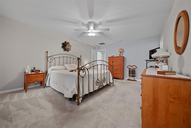 bedroom with visible vents, light colored carpet, ceiling fan, a textured ceiling, and baseboards