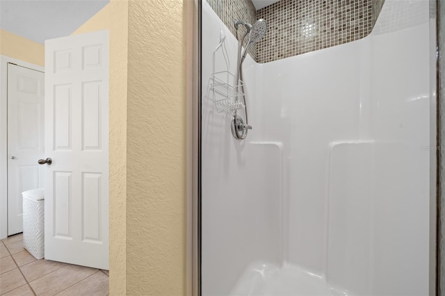 full bathroom featuring walk in shower, a textured wall, and tile patterned floors