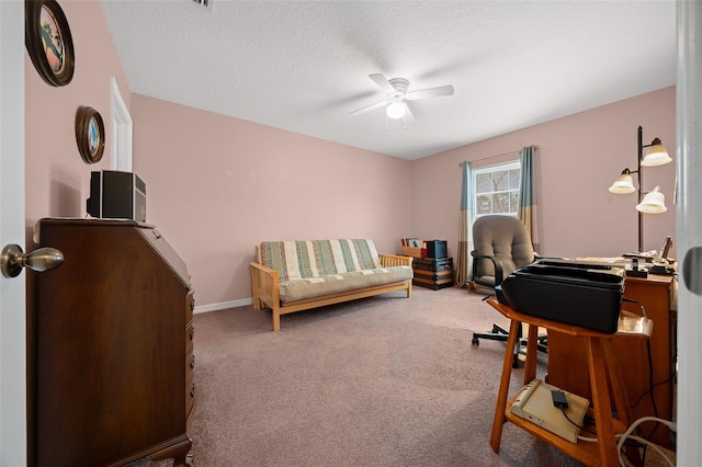 office featuring a textured ceiling, carpet, a ceiling fan, and baseboards