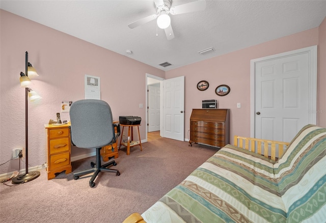 carpeted office featuring visible vents, ceiling fan, a textured ceiling, and baseboards