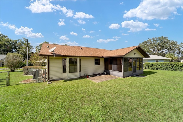 rear view of house with a gate, a yard, fence, and a sunroom