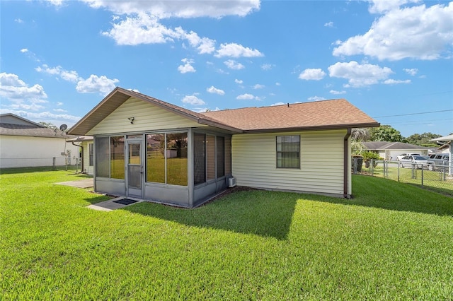 back of house with fence, a yard, and a sunroom