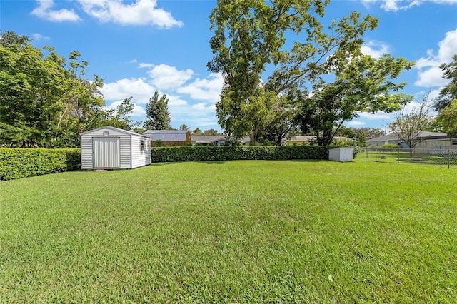 view of yard with an outbuilding, a shed, and fence