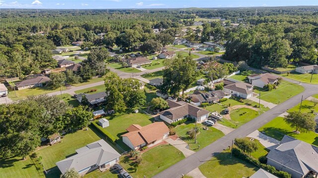 drone / aerial view featuring a residential view and a wooded view