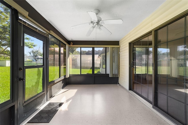 unfurnished sunroom featuring visible vents and ceiling fan