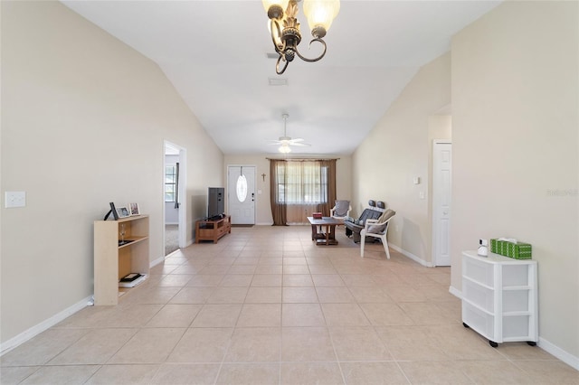 foyer entrance with vaulted ceiling, light tile patterned floors, ceiling fan with notable chandelier, and baseboards