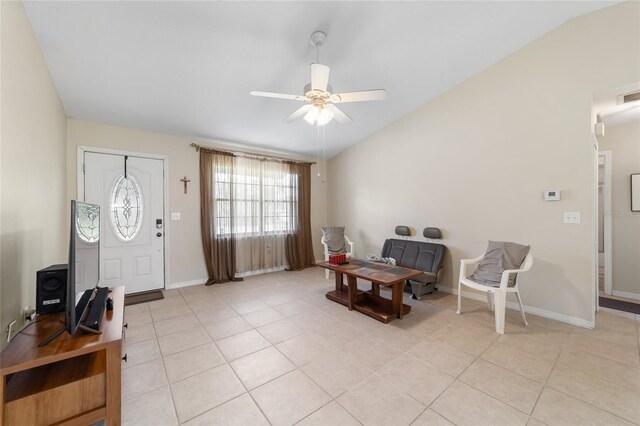 entryway featuring baseboards, lofted ceiling, light tile patterned flooring, and a ceiling fan