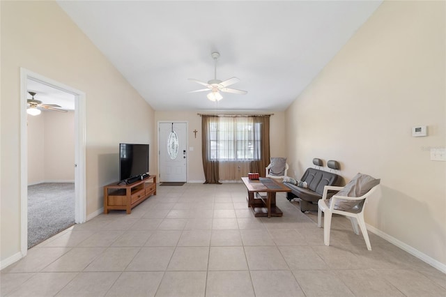 living area with vaulted ceiling, light tile patterned floors, a ceiling fan, and baseboards