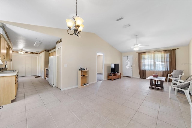 living area featuring vaulted ceiling, light tile patterned flooring, ceiling fan with notable chandelier, and visible vents