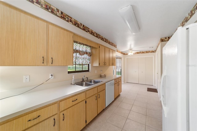 kitchen with light brown cabinets, a sink, white appliances, light countertops, and light tile patterned floors