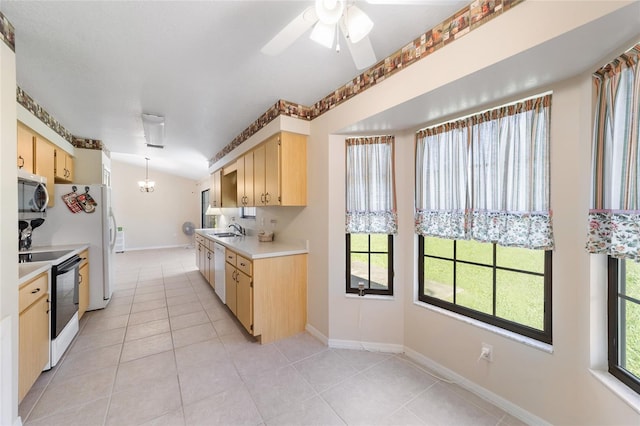 kitchen featuring white dishwasher, a sink, range with electric cooktop, light countertops, and stainless steel microwave