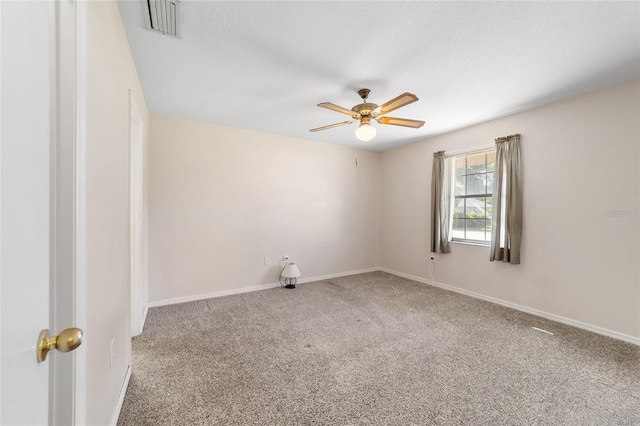 carpeted spare room featuring visible vents, baseboards, a textured ceiling, and ceiling fan