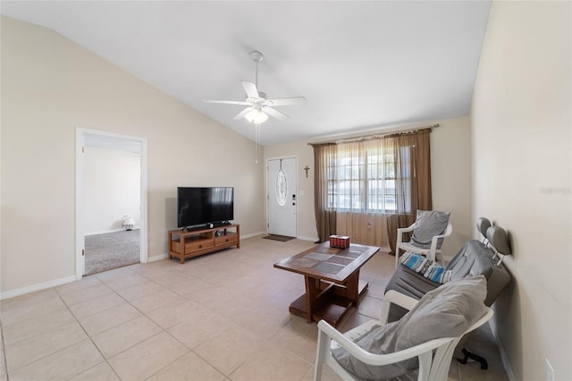 living area with light tile patterned flooring, baseboards, ceiling fan, and vaulted ceiling