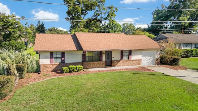 ranch-style house featuring a front yard, an attached garage, brick siding, and driveway