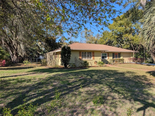 single story home with a front lawn and fence