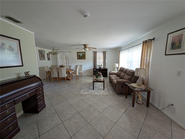 living room with light tile patterned floors, visible vents, crown molding, and a ceiling fan