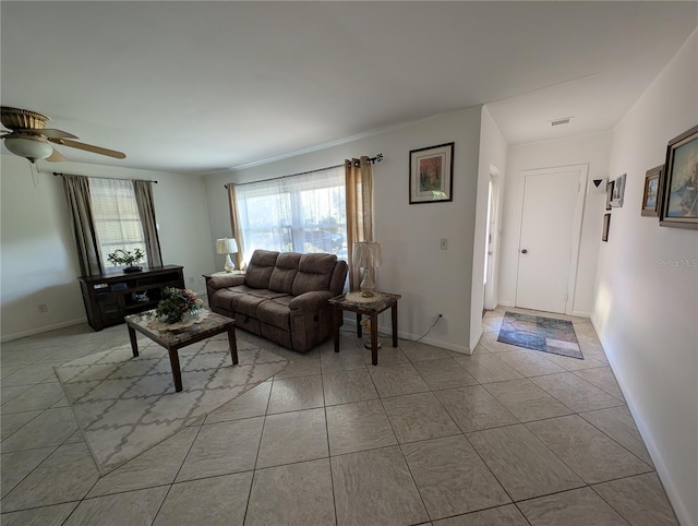 tiled living area with baseboards, visible vents, and ceiling fan