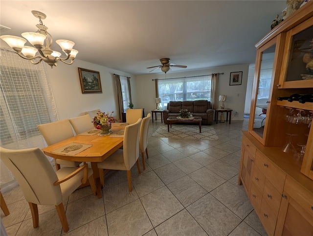 dining space featuring light tile patterned floors and ceiling fan with notable chandelier