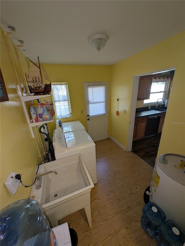 laundry area with a sink, laundry area, wood finished floors, and washing machine and clothes dryer