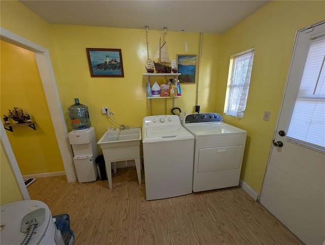 washroom with laundry area, light wood-style flooring, baseboards, and independent washer and dryer