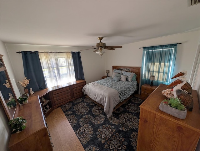 bedroom featuring visible vents, wood finished floors, and a ceiling fan