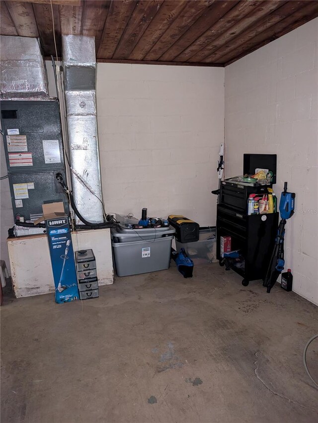 basement with wooden ceiling and concrete block wall