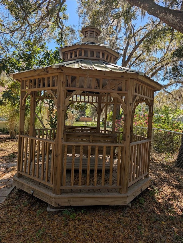 view of community featuring a gazebo, a wooden deck, and fence