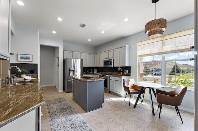 kitchen featuring stainless steel appliances, a kitchen island, visible vents, and gray cabinetry